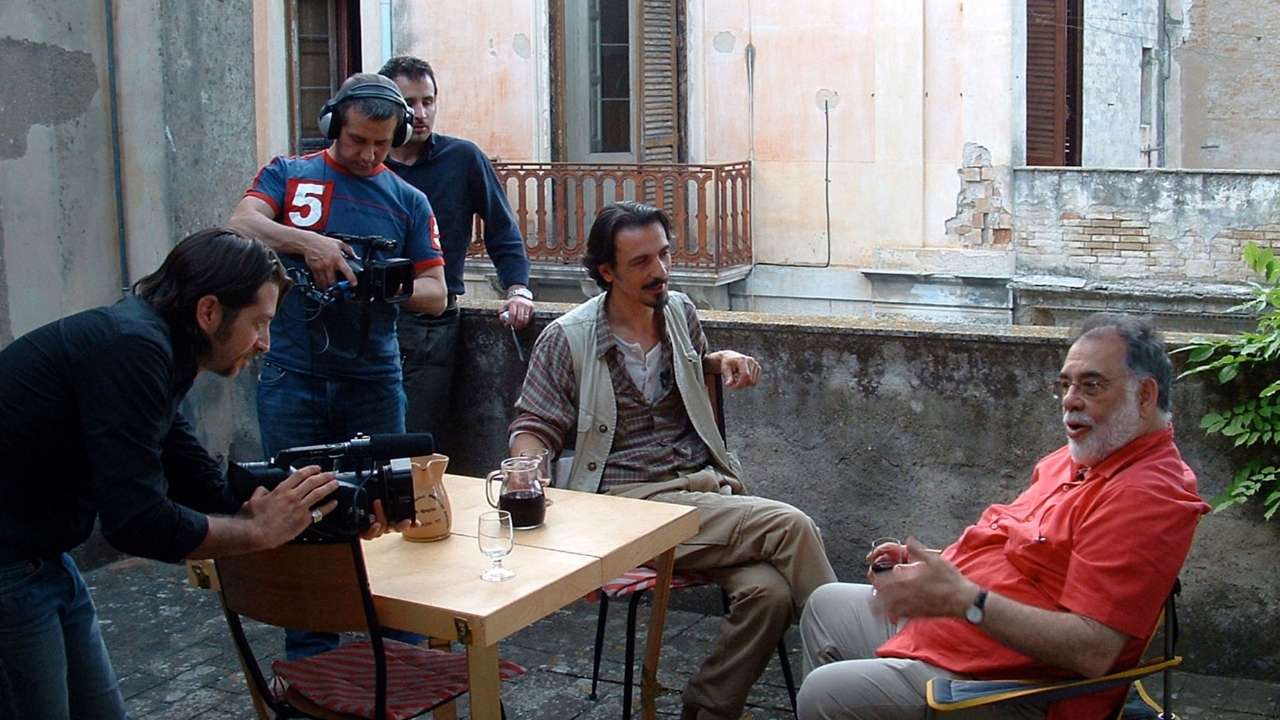 Group of people filming two men talking